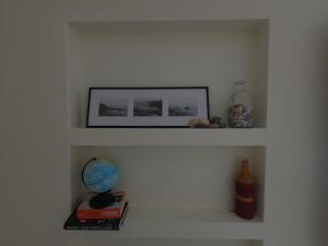 a shelf with a picture and a globe and books at Hakuna Matata Hostel in Zambujeira do Mar