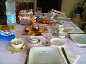 einen Tisch mit einem weißen Tischtuch mit Tellern und Gläsern in der Unterkunft Affittacamere Le Meridiane in Maissana