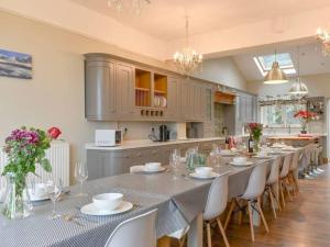 cocina grande con mesa larga y sillas en Chambercombe Villa - Harbour View, Decking, Garden, Games Room, sleeps 20, en Ilfracombe