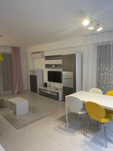 een woonkamer met een witte tafel en stoelen bij Tranzzit Airport Apartment II in Otopeni