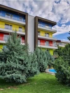 un edificio de apartamentos con árboles delante de él en Tranzzit Airport Apartment II, en Otopeni