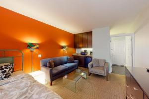 a bedroom with orange walls and a bed and a kitchen at Bella Paradiso 12 in Eureka Springs