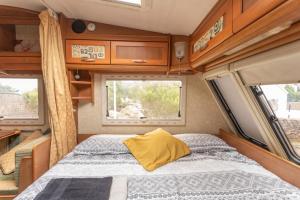 a bed in an rv with a yellow pillow at Villaverde Glamping in Villaverde
