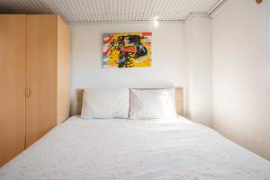 a bedroom with a bed with a painting on the wall at Central, Cozy, Comfy, 1BR House, Free Parking & Fast Wi-Fi, 4ppl in Bodrum City