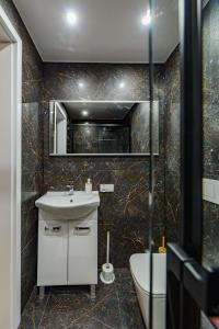 a bathroom with a sink and a mirror and a tub at Apartament Pod Dwójką in Bielsko-Biała