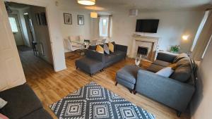 uma sala de estar com dois sofás e uma lareira em CEDAR HOUSE - Spacious 4Bedroom House 2Bath Kitchen SmartTV Lounge Garden Wifi FreeParking em Eastleigh