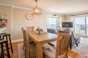 a dining room with a wooden table and chairs at Oceanfront Condo with 3+ Pools - Ocean Dunes 1701 in Kure Beach