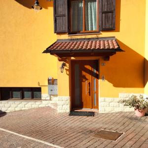 un edificio amarillo con puerta y ventana en Apartment Serena, en Ronzo Chienis