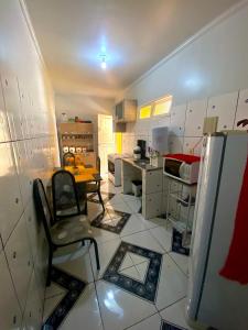 a kitchen with a chair and a table and a refrigerator at Casa de Charles in Piranhas