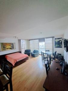 1 dormitorio con 1 cama, mesa y sillas en Exclusive Furnished Apartment 4, en Manizales