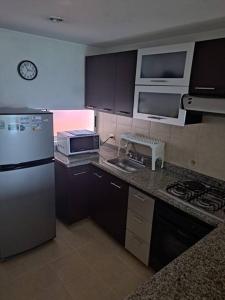 cocina con nevera, fregadero y microondas en Exclusive Furnished Apartment 4, en Manizales
