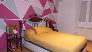 1 dormitorio con cama y pared geométrica en THE QUEEN, en Arcas