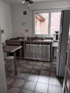 una cocina con fregadero y mesa. en Au répit centre Thermes Luxeuil T3 en Luxeuil-les-Bains