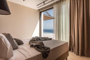 a bedroom with a bed with a large window at Limnionas Serenity Cave Villa in Kampion