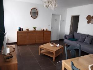 ein Wohnzimmer mit einem Sofa und einem Tisch in der Unterkunft Au répit centre Thermes Luxeuil T3 in Luxeuil-les-Bains