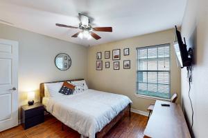 een slaapkamer met een bed en een plafondventilator bij The Pensacola Sanctuary in Pensacola