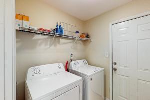 een kleine wasruimte met een wasmachine en droger bij The Pensacola Sanctuary in Pensacola +17 foto's