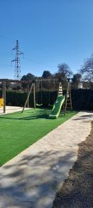 a playground with a green slide at Dehesa Vieja Casa Rural in Alarcón
