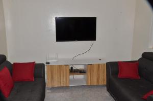 a living room with two couches and a flat screen tv at Appartement Luxueux in Dakar