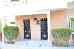 a house with a blue and white mattress in front of a black door at Appartement Luxueux in Dakar +5 photos