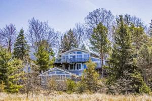 a large blue house in the middle of trees at 2nd Base - Main Home in Sawyer +20 photos