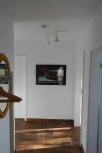 キールにあるFerienwohnung im Kieler Südenの白い壁の客室で、壁にテレビが付いています。