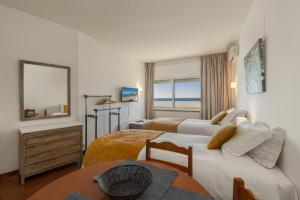 a hotel room with two beds and a table at Apartamentos Pescadores in Albufeira