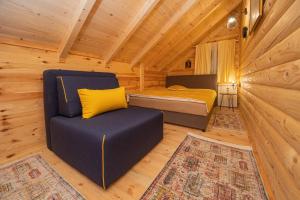a bedroom with a bed and a chair in a cabin at Rustic house in Kolašin