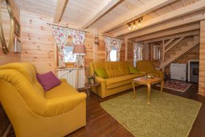 Rustic house في كولاسين: غرفة معيشة بها كنبتين صفراء وطاولة