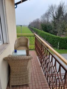 een balkon met een tafel en stoelen en een raam bij Casa Pepo in Precenicco