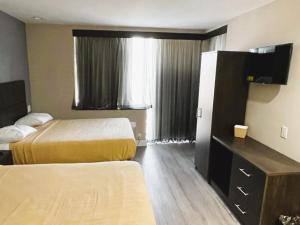 a hotel room with two beds and a window at Royal Hotel Bronx in Bronx