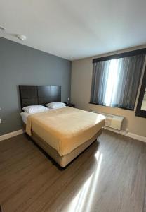 a bedroom with a large bed and a large window at Royal Hotel Bronx in Bronx