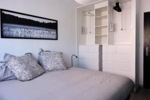 um quarto com uma cama branca e 2 almofadas em Two bedrooms modern apartment close to Tram em Toulouse