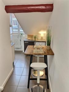 a small kitchen with a table and a stool at Wonderhost, le calme en coeur de ville in Pau +7 photos