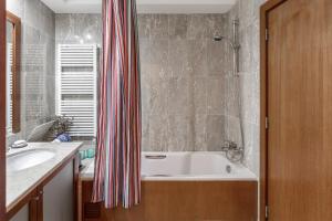 La salle de bains est pourvue d'une baignoire, d'un lavabo et d'une douche. dans l'établissement SEAMatosinhos, à Matosinhos