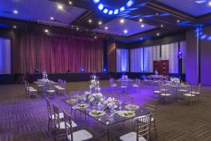 un salón de banquetes con mesas, sillas e iluminación púrpura en Jewel Palm Beach, en Punta Cana