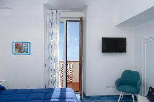 a bedroom with a blue bed and a sliding glass door at Amalfi Sea View in Scala