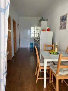 eine Küche mit einem Tisch und Stühlen sowie einem Kühlschrank in der Unterkunft Casa Suso in El Remo