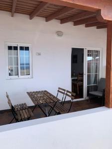 eine Terrasse mit 2 Stühlen, einem Tisch und einem Sofa in der Unterkunft Casa Suso in El Remo