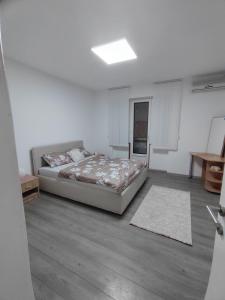 a bedroom with a bed in a white room at Queen 3 in Niš