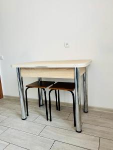 un tavolo in legno con una sedia accanto di Охайна двокімнатна квартира біля Дніпра! a Čerkasy