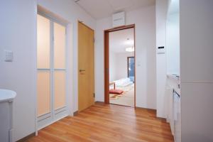 einen Flur mit einer Tür, die zu einem Schlafzimmer führt in der Unterkunft TOKIHouse 京都時光 in Kyoto