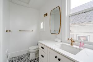 Baño blanco con lavabo y espejo en The World's Fair Home, en Portland