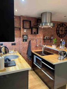 a kitchen with a sink and a brick wall at Escale Studio 21m Aéroport CDG Parc expo Astérix in Gonesse