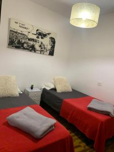 モライラにあるCasa Platgetesの赤いシーツとポスター付きのベッド2台が備わる客室です。