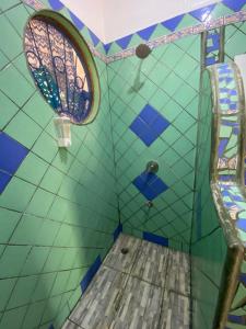 um quarto com paredes em azulejo azul e verde e uma janela em Casa Maiana em Sámara