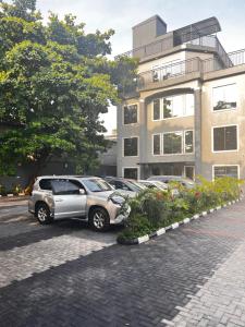 un parcheggio con auto parcheggiate di fronte a un edificio di De Rigg Place Embassy a Lagos