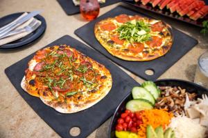 two pizzas and a bowl of food on a table at Sunriver Resort in Sunriver +86 photos