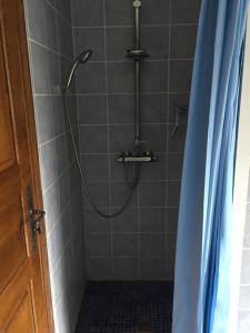 een douche met een douchegordijn in de badkamer bij La Maison aux Roses in Vaux-en Couhé