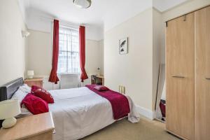 a bedroom with a bed and a window with red curtains at Grove House - By Sigma Stays in Newcastle under Lyme